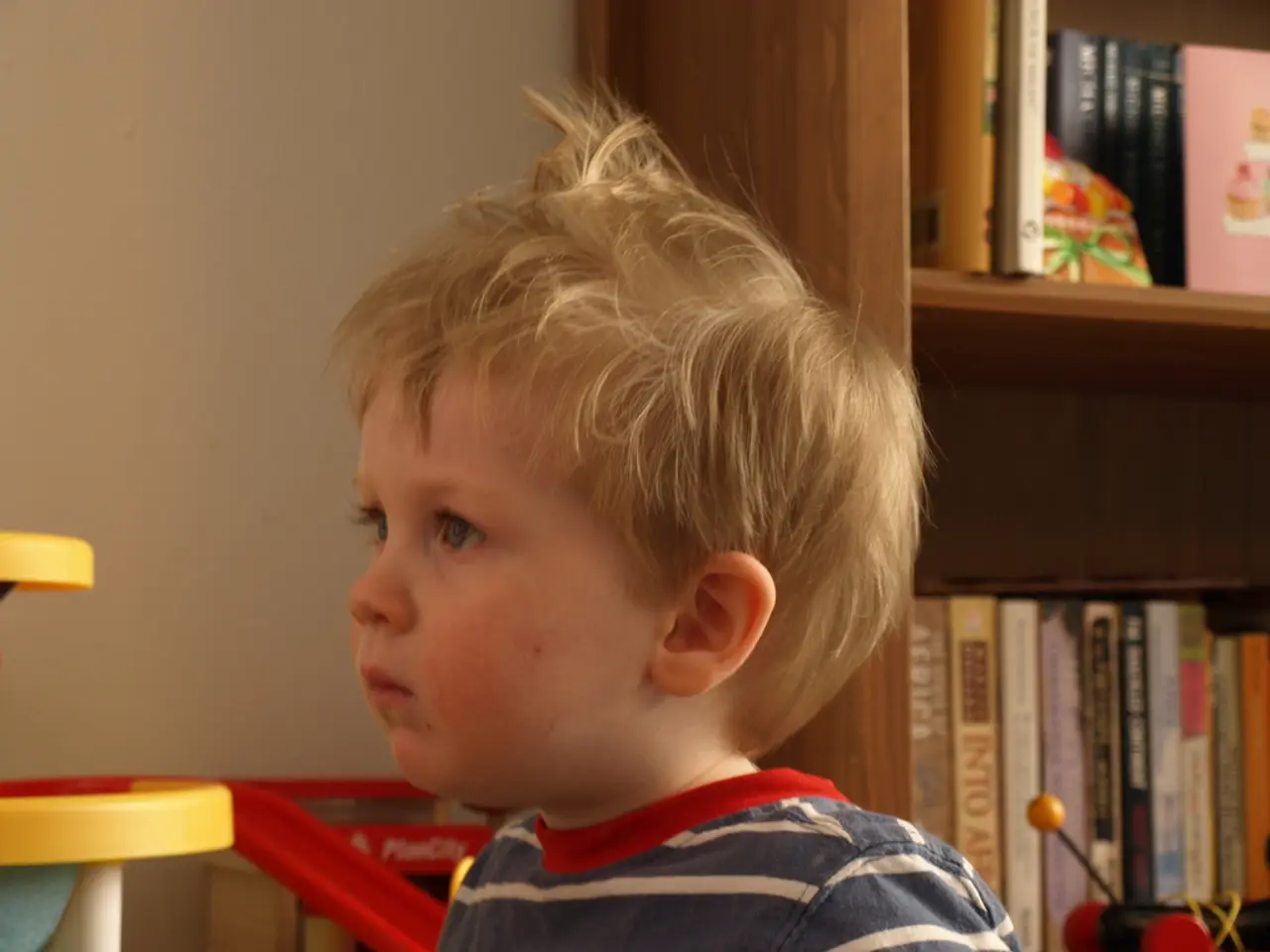 In this picture we can see a kid in the front, on the right side there is a rack, we can see some...