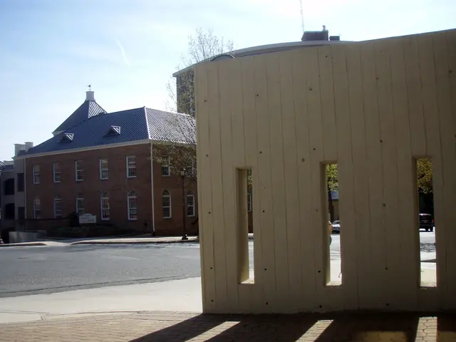 In this picture there is a building on the left side of the image and there is a wall on the right...