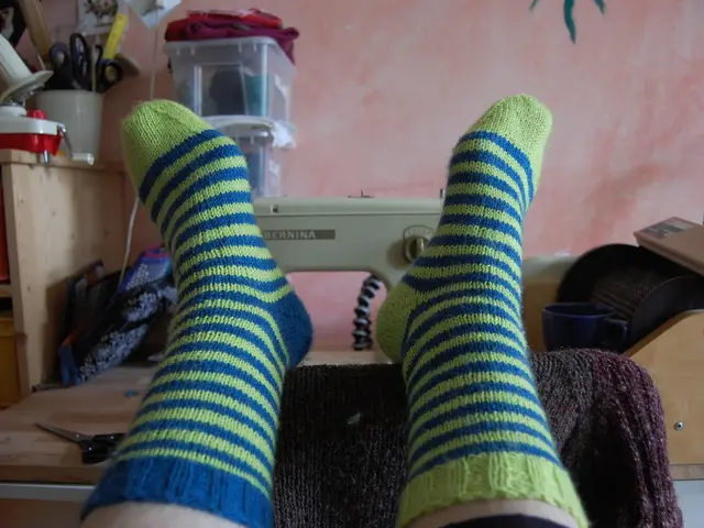 In this picture we can see a person wore socks, scissors, sewing machine, boxes, baskets, wall,...