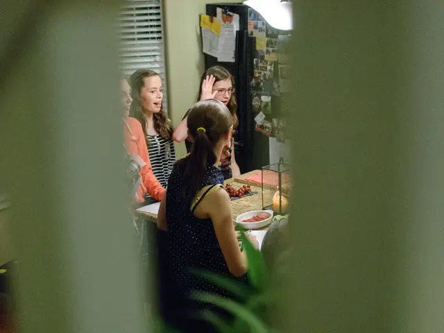 As we can see in the image there are few people over here, a wall, photos and table. On table there...