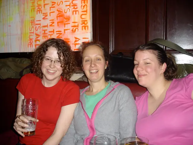 In this picture there are ladies those who are sitting in the center of the image, by holding...