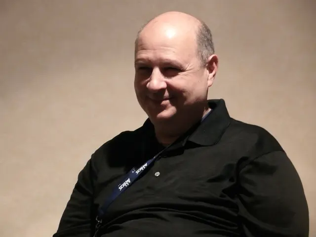 In this image in the center there is one person who is smiling, and in the background there is a...