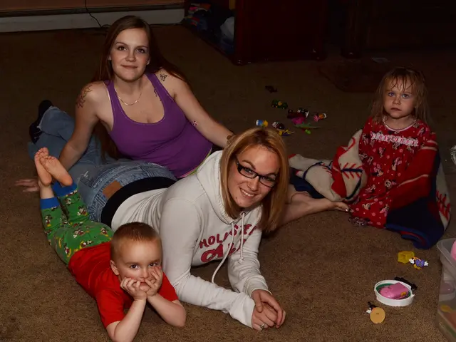 In this image we can see women and children lying on the floor. In addition to this we can see a...